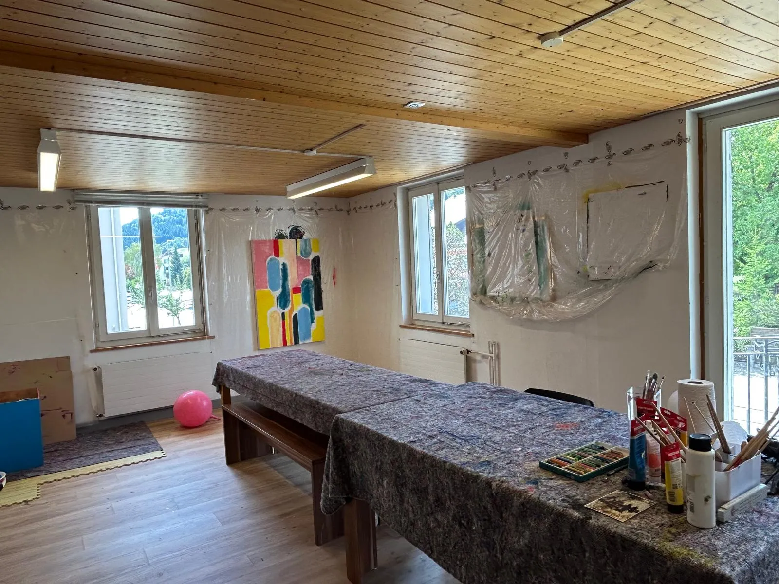 Der helle Atelierraum mit dem grossen Maltisch